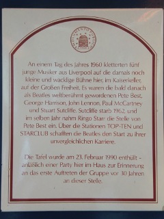 An einem Tag des Jahres 1960 kletterten fnf junge Musiker aus Liverpool auf die damals noch kleine und wacklige Bhne hier, im Kaiserkeller, auf der Groen Freiheit. Es waren die bald danach als Beatles weltberhmt gewordenen Pete Best, George Harrison, John Lennon, Paul McCartney und Stuart Sutcliffe. Sutcliffe starb 1962, und im selben Jahr nahm Ringo Starr die Stelle von Pete Best ein. ber die Stationen TOP-TEN und STARCLUB schafften die Beatles den Start zu ihrer unvergleichlichen Karriere.  Die Tafel wurde am 23. Februar 1990 enthllt anllich einer Party hier im Haus zur Erinnerung an das erste Auftreten der Gruppe vor 30 Jahren an dieser Stelle.